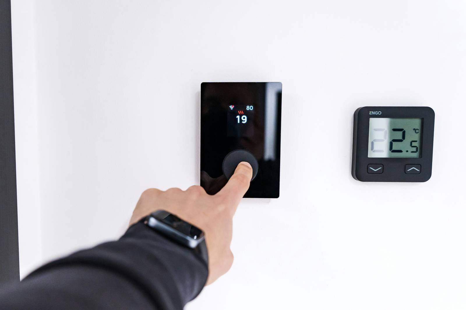 Resident adjusting a smart thermostat in a bright, upgraded home